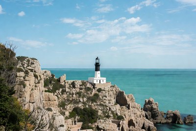 White lighthouse on rocky cliff