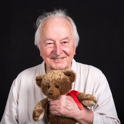 Elderly man holding teddy bear