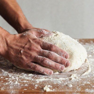 Man kneading dough on table