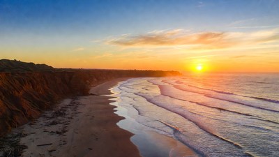 Sunset over red cliff beach
