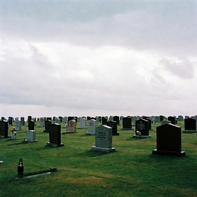 Graveyard with tombstones under cloudy sky