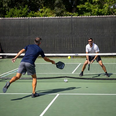Two men playing pickleball on court
