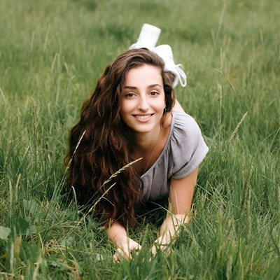 Smiling woman lying in green grass