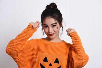 Asian woman in orange jack-o-lantern sweater