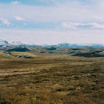 Snowy Peaks Over Rolling Tundra Hills