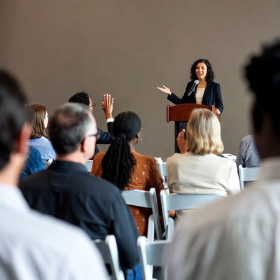Woman speaking at podium with audience