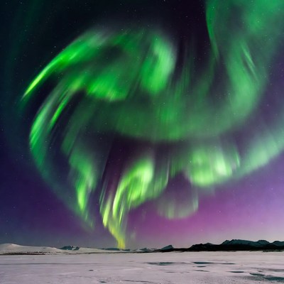 Vibrant green northern lights over snowy landscape