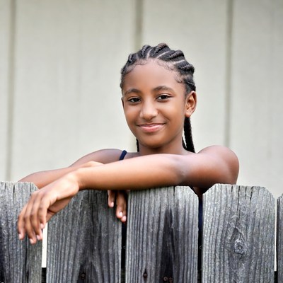 African-American girl leaning on fence