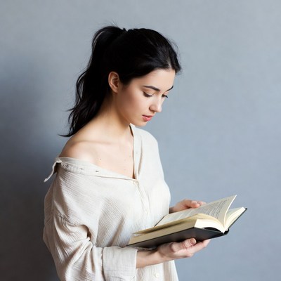 Woman reading book in off-shoulder shirt