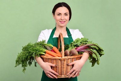 Woman holding basket of fresh vegetables