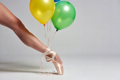 Ballerina leg holding yellow green balloons