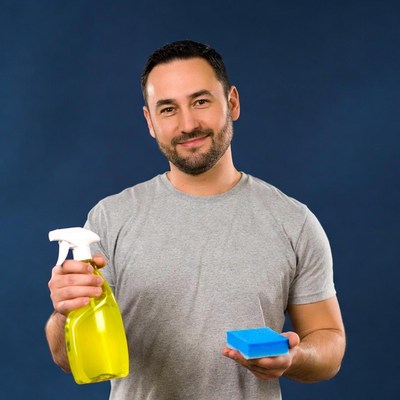 Man holding yellow spray bottle and blue sponge