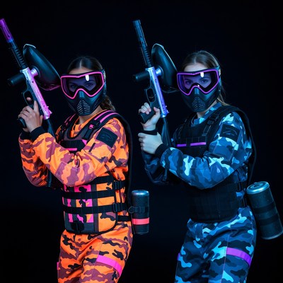 Two girls in paintball gear with guns