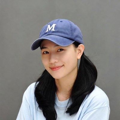 Asian girl smiling in navy M cap