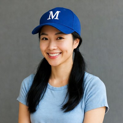 Asian woman smiling in blue M cap