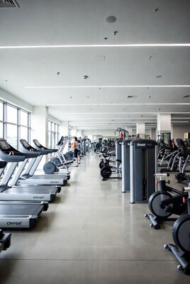 Modern gym with treadmills and woman exercising