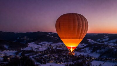 Hot air balloon over snowy village