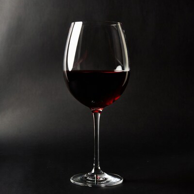 Red wine in glass on black background