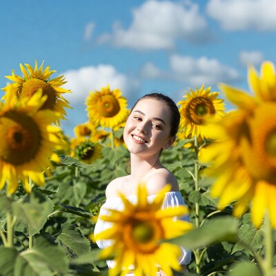 Asian woman smiling in sunflower field