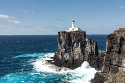 White lighthouse on ocean cliff