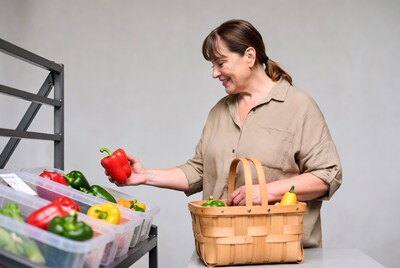 Woman picking red bell pepper at market