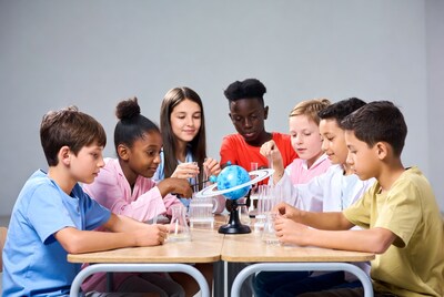 Diverse children studying solar system model