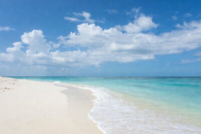 Turquoise ocean waves on white sand beach