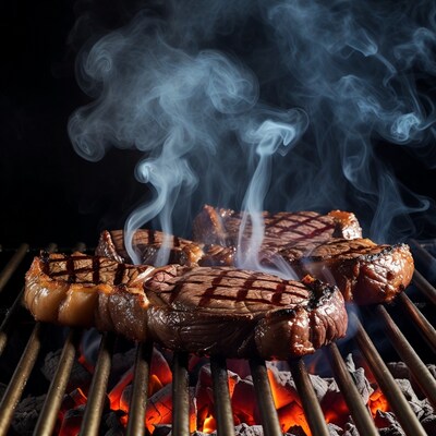 Grilled steaks smoking on barbecue grill