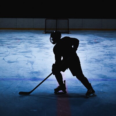 Silhouette hockey player shooting at goal