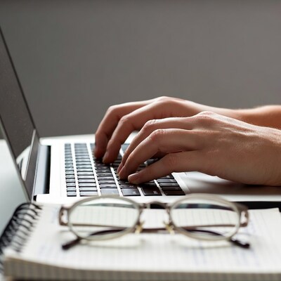 Hands typing on laptop keyboard