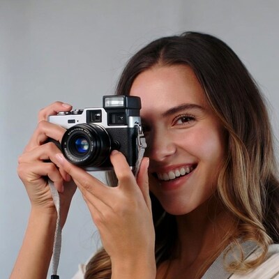 Woman holding vintage camera smiling