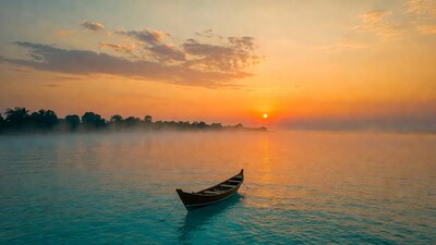 Traditional boat on misty river at sunset