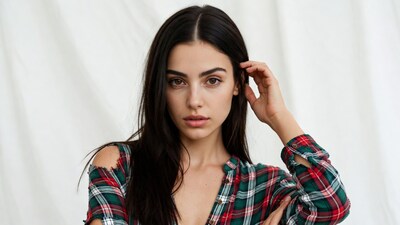 Woman touching hair in plaid shirt
