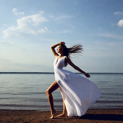 Woman in flowing white dress by lake