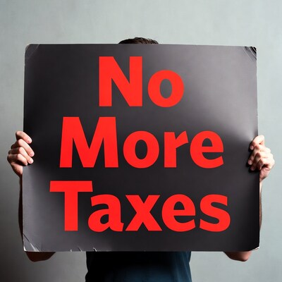 Man holding No More Taxes sign