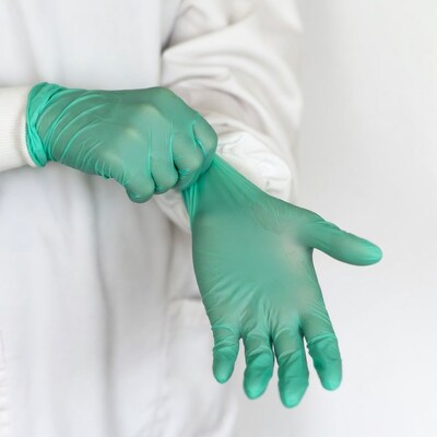 Person putting on green gloves