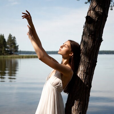 Woman dancing by tree and lake
