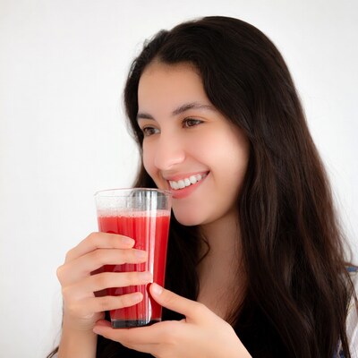 Young woman drinking red juice