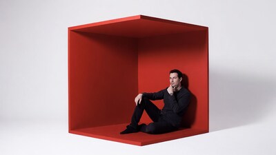 Man sitting in red cube
