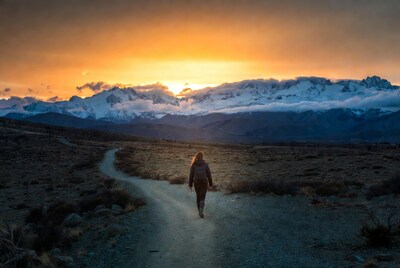 Woman walking trail at sunset mountains