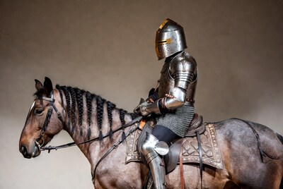 Knight in armor riding horse