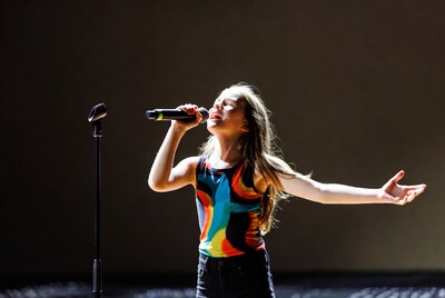 Girl singing with microphone on stage