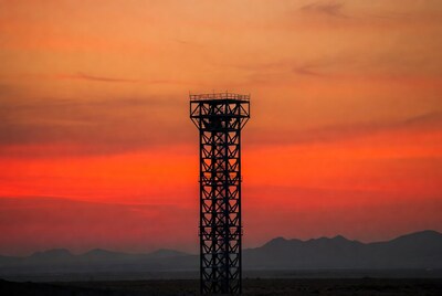 Steel tower silhouetted against sunset