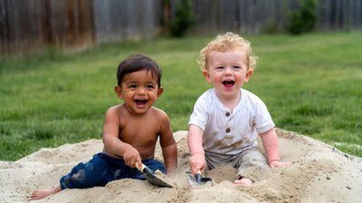 Two boys playing with shovels in sand