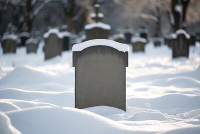 Snowy gravestone in winter cemetery