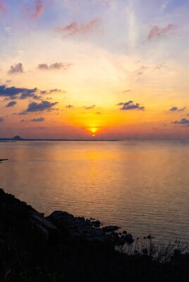 Sunset over calm sea with rocks
