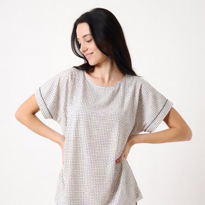 Smiling woman in printed blouse hands on hips