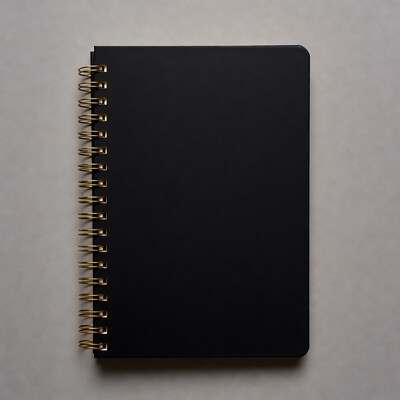 Black spiral notebook on gray background