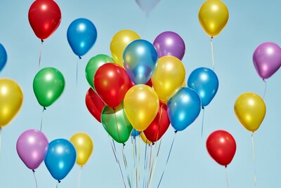 Colorful Balloons Floating Against Blue Sky