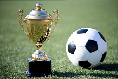 Golden Soccer Trophy with Ball on Grass